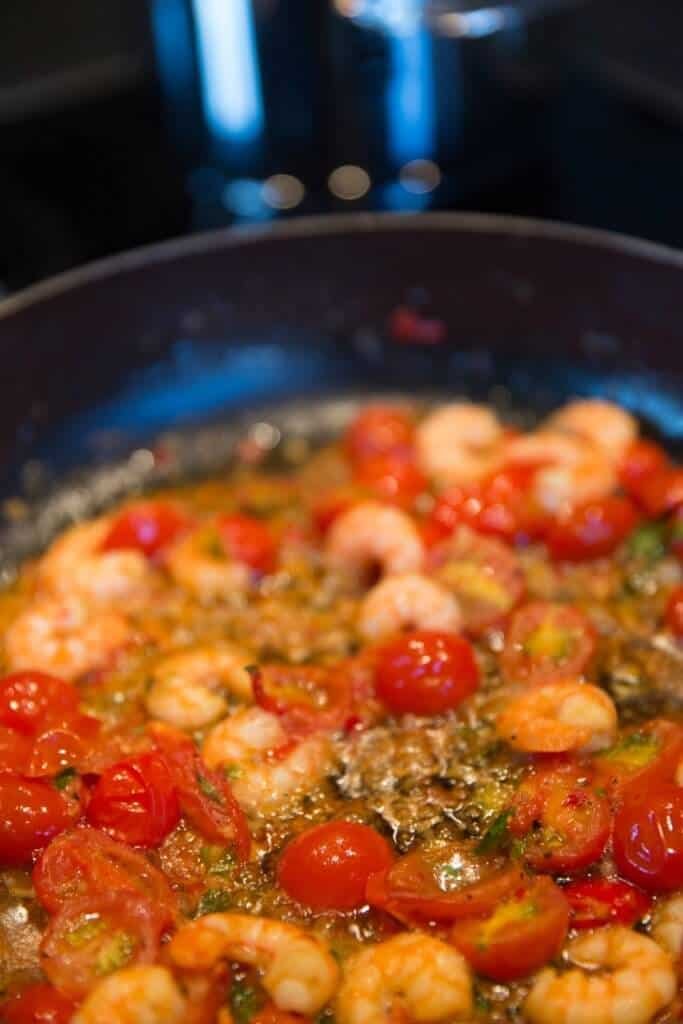 shrimp being sauteed with cherry tomatoes